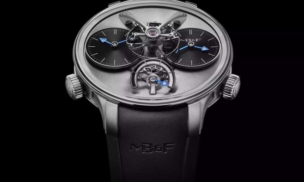 MB&F LM1 EVO armbandsur i titan med borstad grå grundplatta, två svarta urtavlor med blå visare, synlig balans i mitten och svart integrerat gummiarmband.