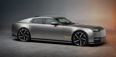 Jaguar Type 01 från sidan, en låg fyradörrars elbil i grått med stora hjul