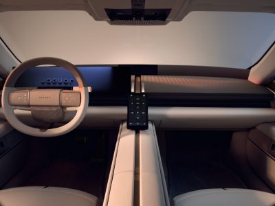 Interiören i Jaguar Type 01 med ratt, bred instrumentpanel och lång mittkonsol Beskrivning: Förarmiljön i Jaguar Type 01 med ljus interiör, en instrumentpanel i en horisontell linje och en mittkonsol som delar kupén