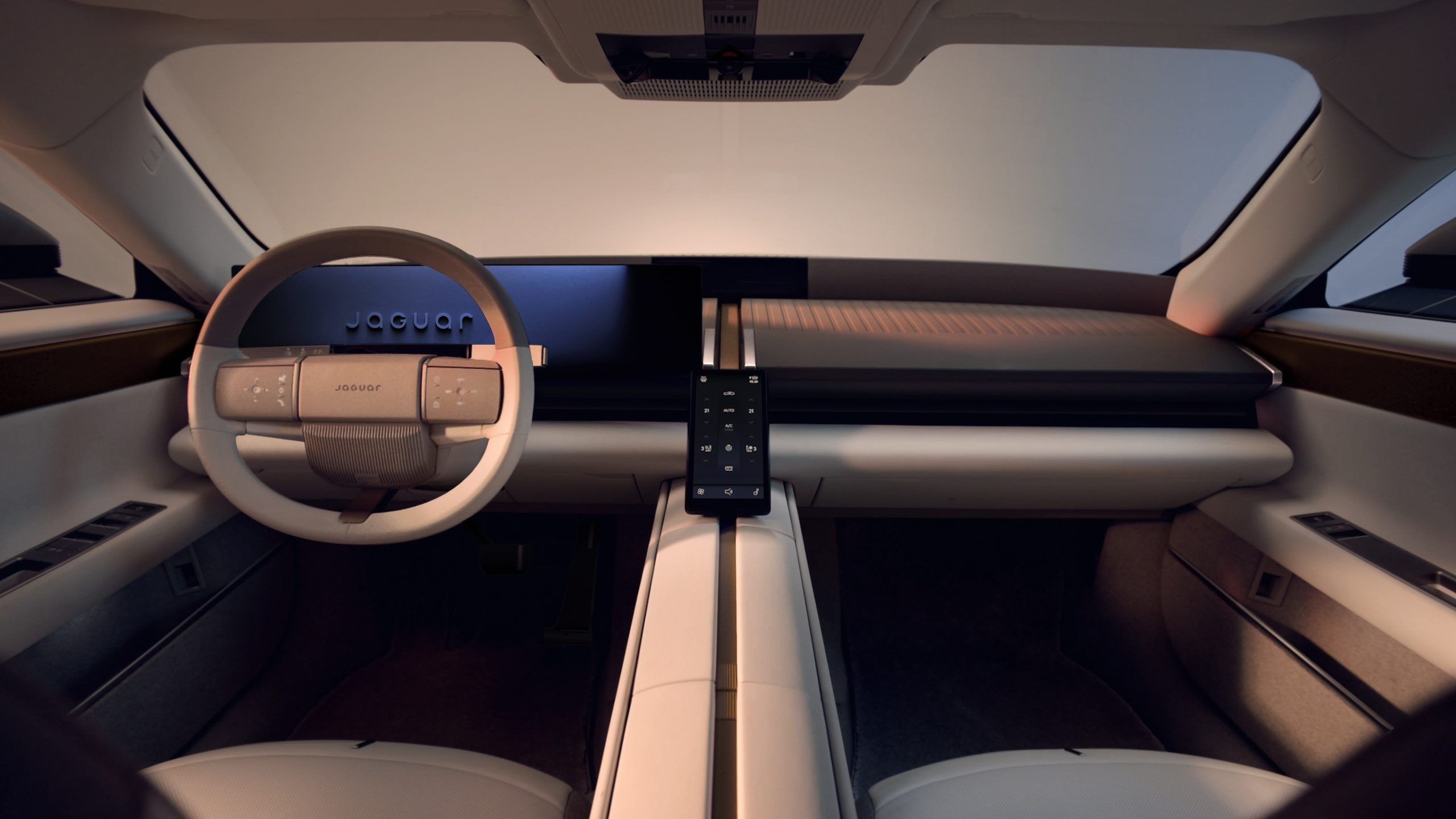 Interiören i Jaguar Type 01 med ratt, bred instrumentpanel och lång mittkonsol Beskrivning: Förarmiljön i Jaguar Type 01 med ljus interiör, en instrumentpanel i en horisontell linje och en mittkonsol som delar kupén